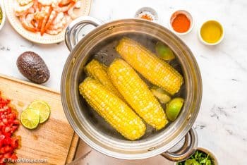 Cooking Corn in pot of water with limes.
