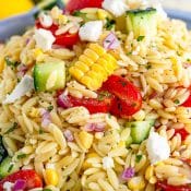 Close up of Orzo Pasta Salad with orzo, corn, peppers, and more in blue serving bowl.