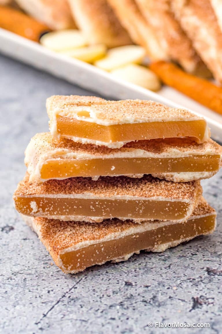 A stack of 4 Churro Toffee bars in front of a platter of more churro toffee.