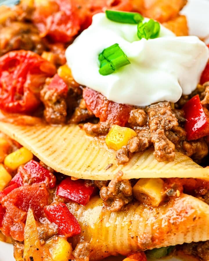 Taco Stuffed Shells topped with sour cream and green onions