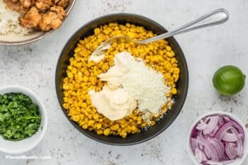 Corn and mayonnaise in a black skillet.