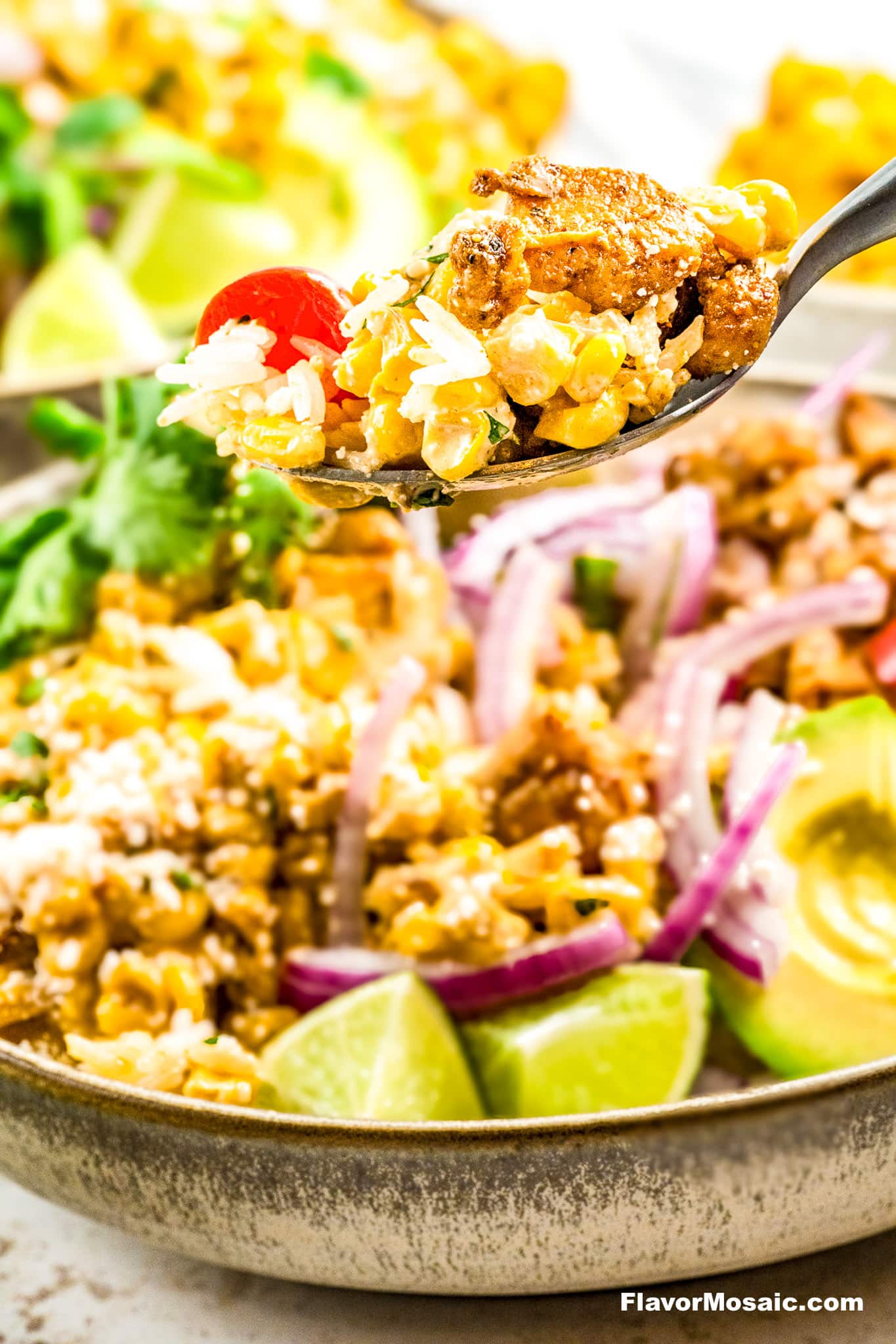 A bite of street corn chicken rice bowl on a fork.