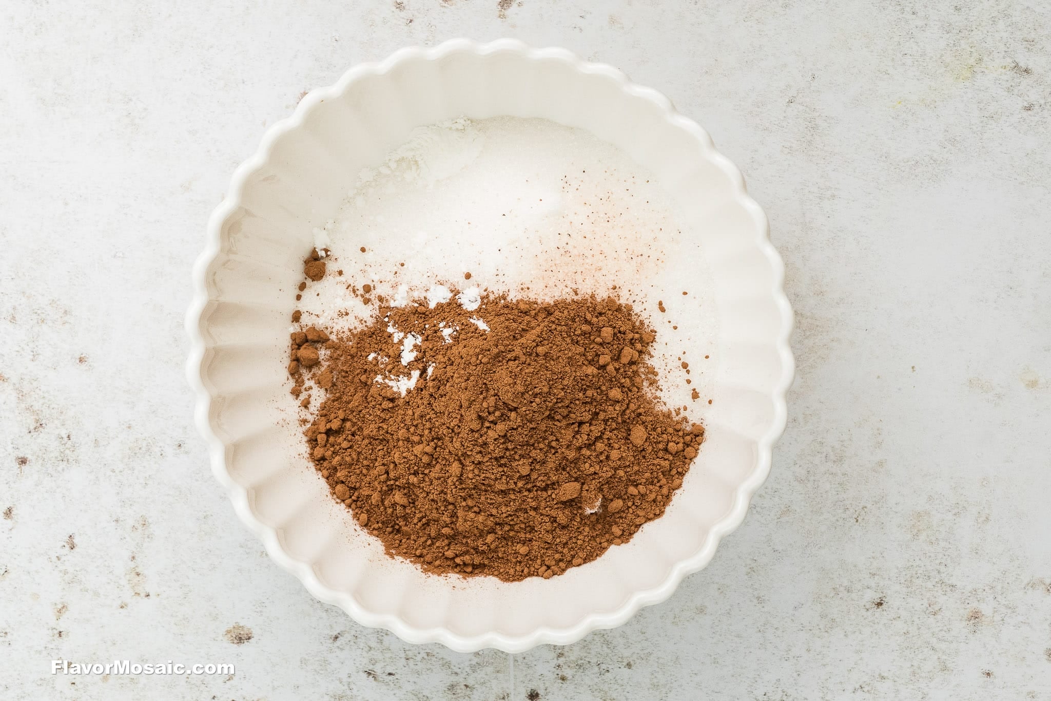 Step 3 How to Make Chocolate Chess Pie - Overhead view of cocoa, sugar, cornstarch and salt in a white bowl on a light colored background.