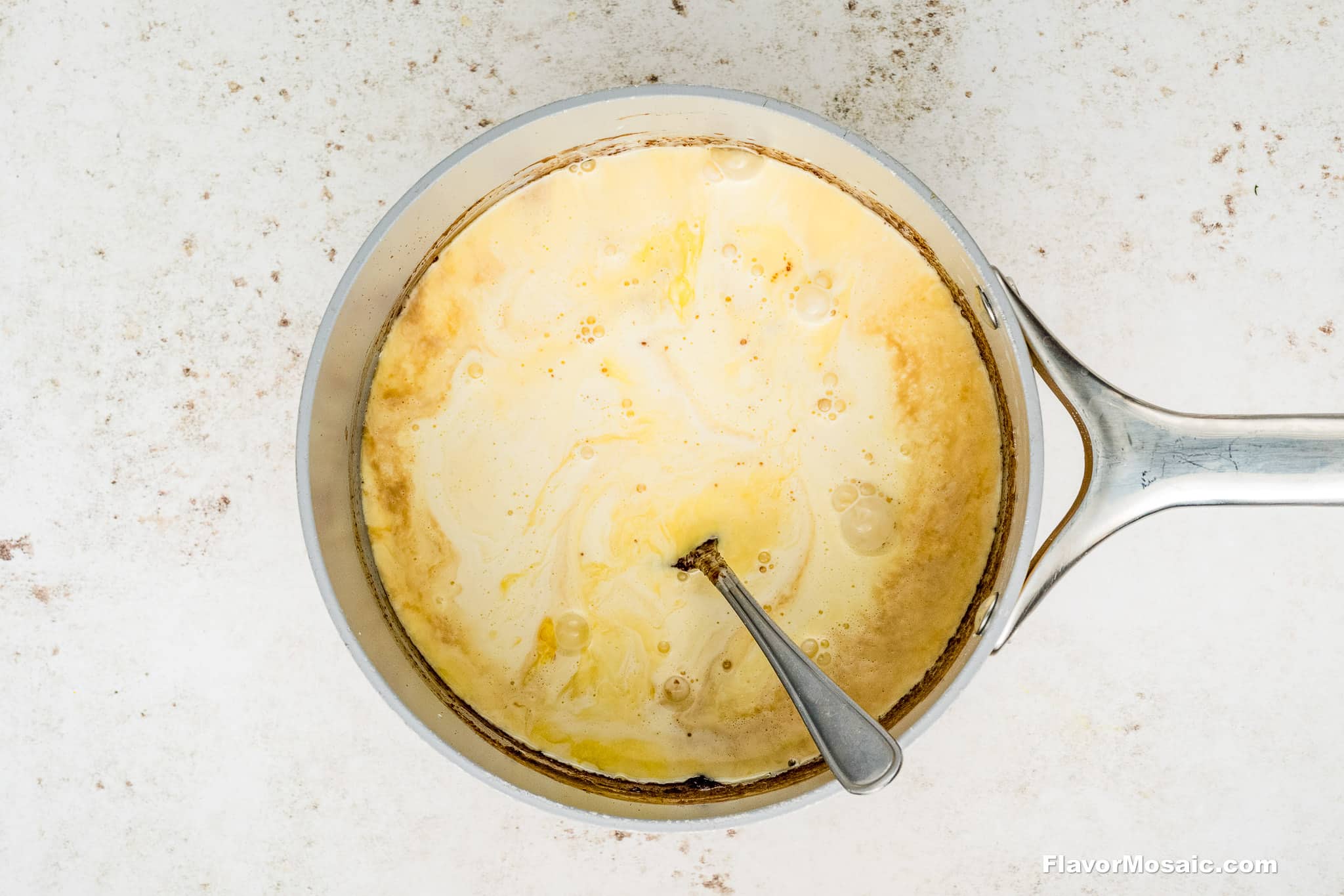 Step 4 - Eggs, evaporated milk and vanilla whisked together in a silver saucepan.